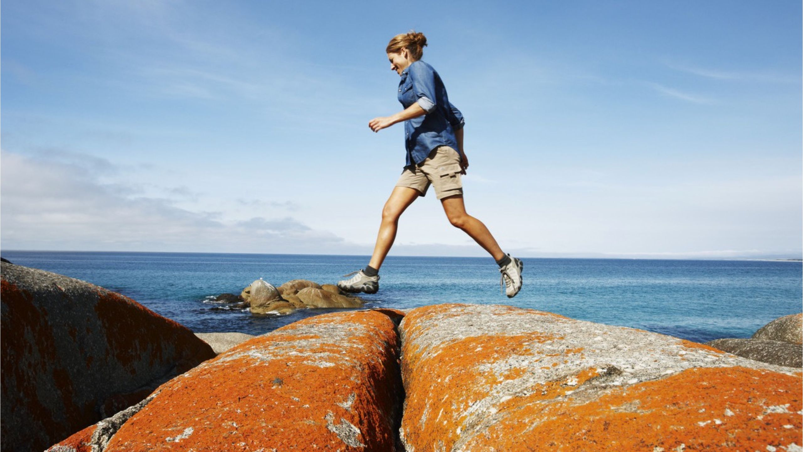 Bay of Fires Lady Walking on Orange Lichen Boulders