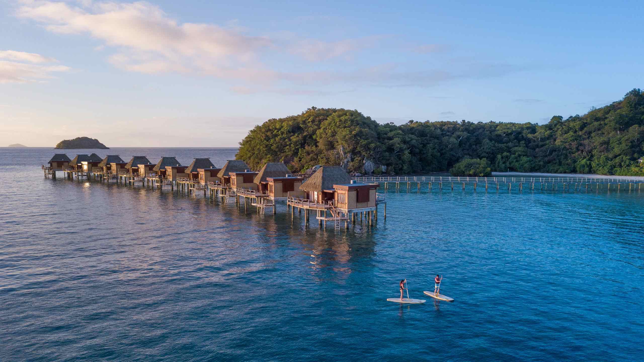 likuliku-lagoon-resort-fiji-aerial-stand-up-paddle-couple-overwater-bungalows